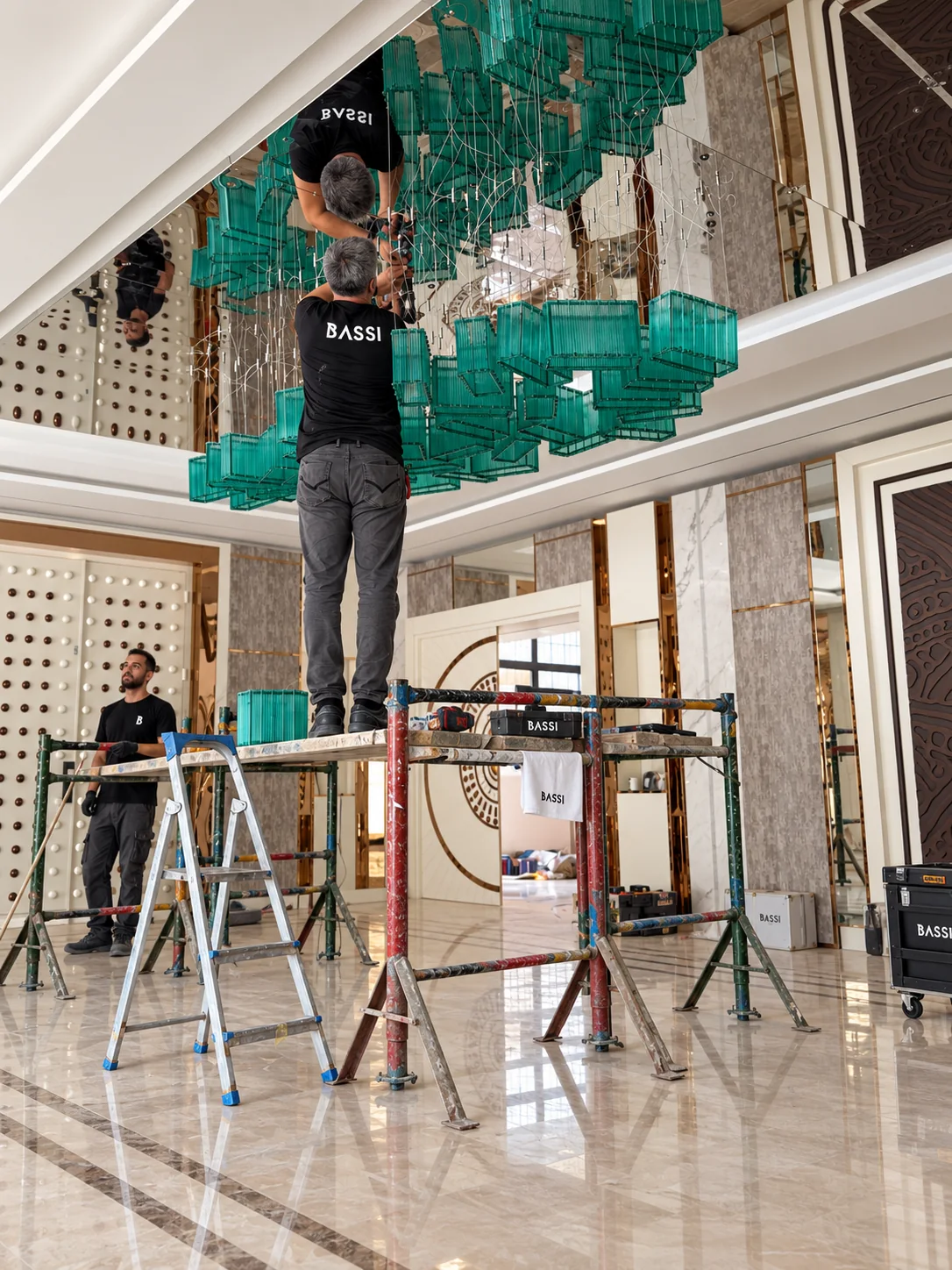 Equipe Bassi instalando o lustre turquesa